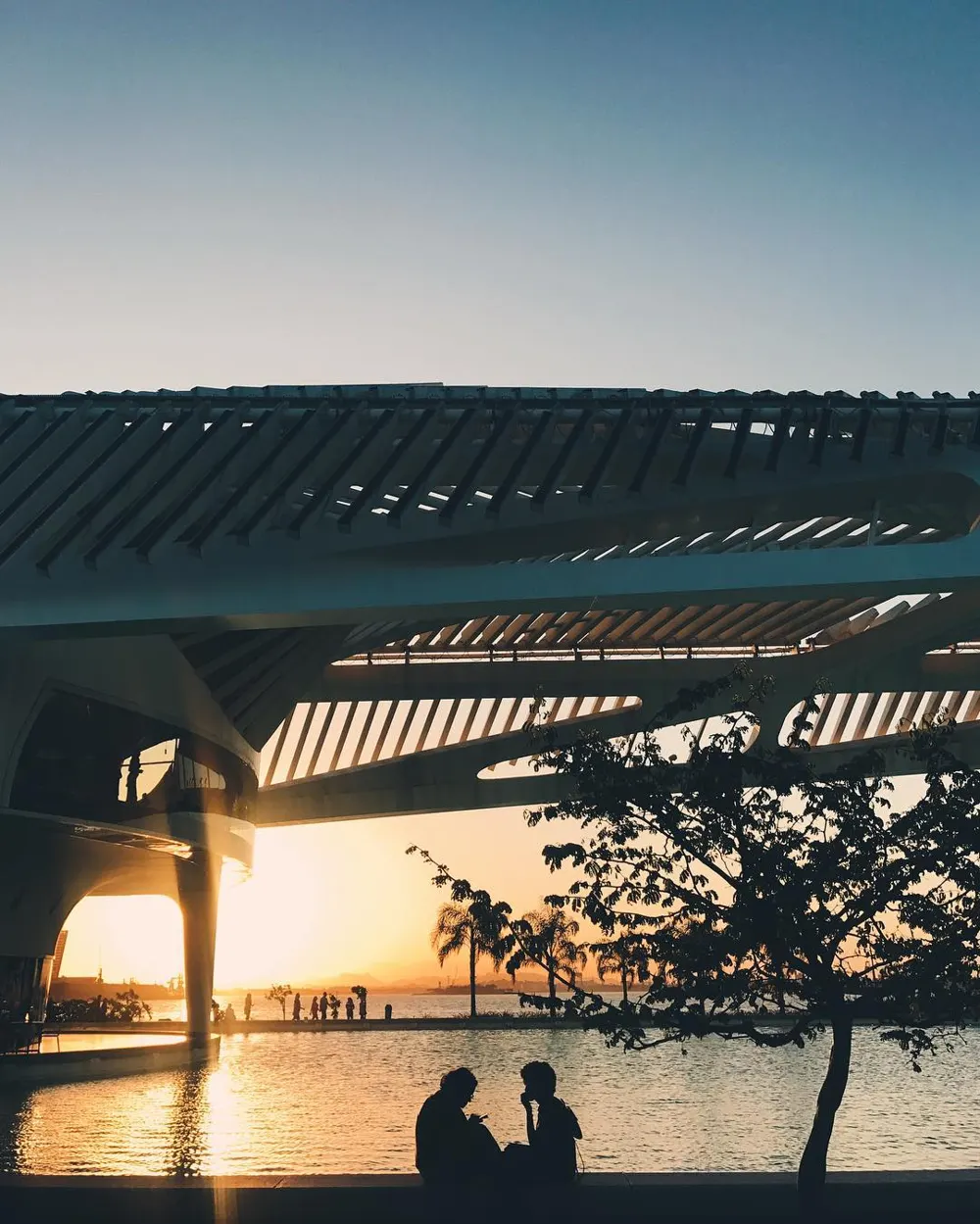Silhueta de casal sob a estrutura do Museu do Amanhã ao pôr do sol